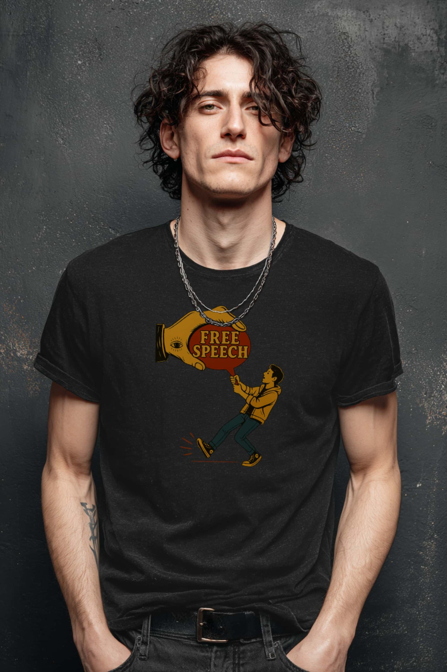 Man with curly dark hair and silver chain wearing Free Speech graphic tee, modern rebellious streetwear look.