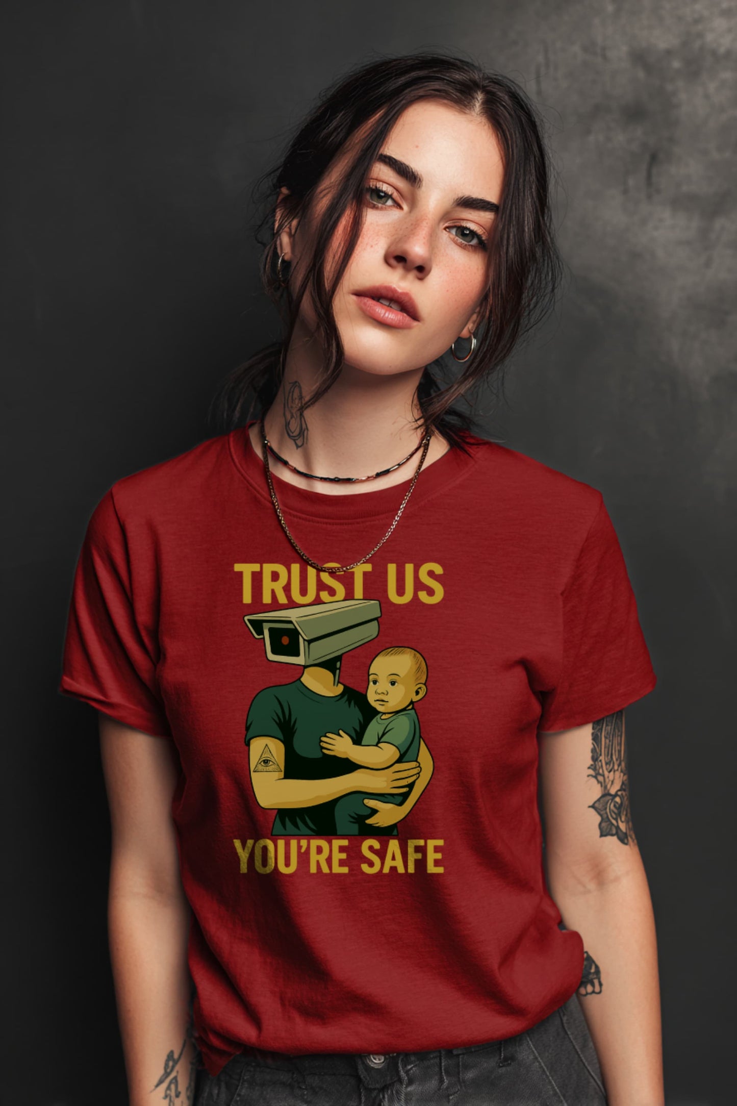 Woman wearing Trust Us You’re Safe t-shirt in red with bold protest surveillance artwork